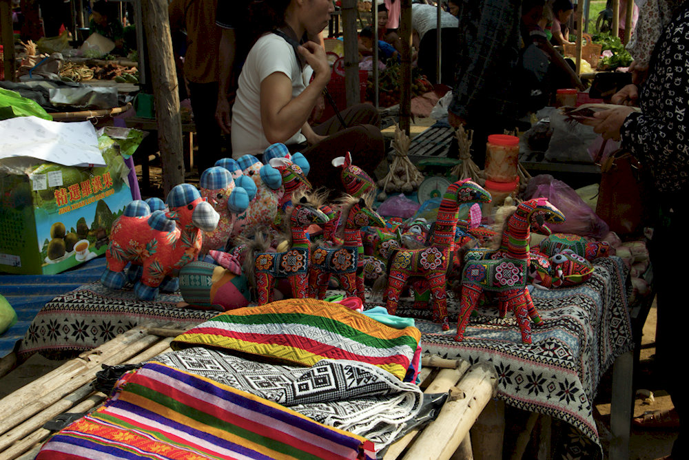 Colorful displays of handmade crafts, traditional textiles, and local spices fill the bustling Pho Doan Market 